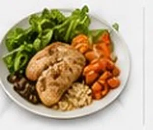 A balanced carry-out lunch plate of roasted chicken, carrots and fresh greens.
