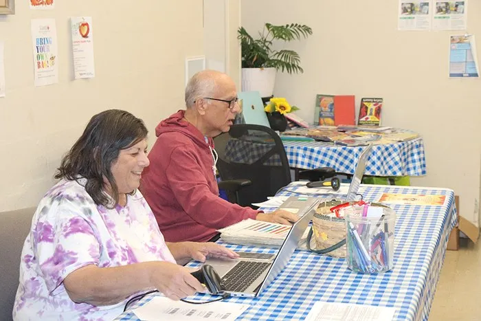 Volunteers welcoming a neighbor at the St. Brigid's check-in table.